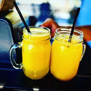 two glasses of orange juice on a table