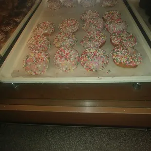 a tray of donuts with sprinkles