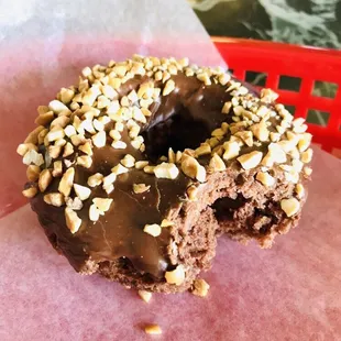 a chocolate frosted donut with nuts