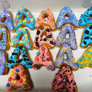 a dozen decorated donuts in a box