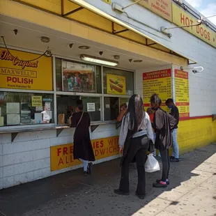 people standing outside of a fast food restaurant