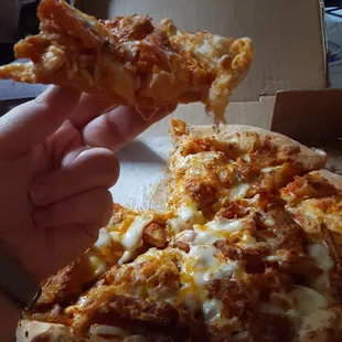 Buffalo chicken pizza with a mountain of cheese, chicken, and buffalo fries.
