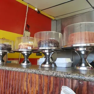 gorgeous layer cakes line the front counter, to be sold by the slice