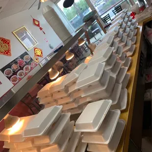 a large number of trays of food on a counter