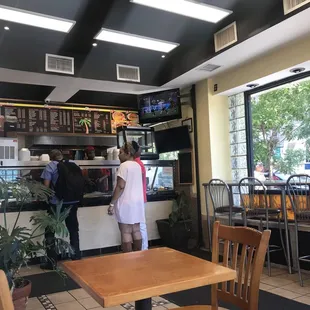 a woman standing at a counter in a restaurant