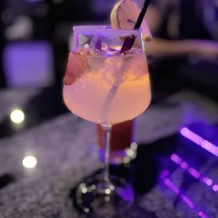 a glass of cocktail on a bar