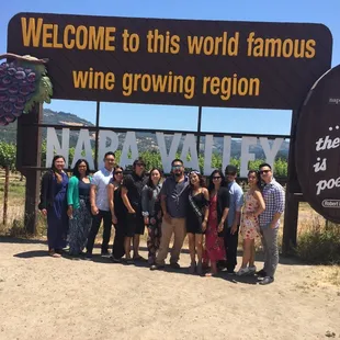 The rolling birthday party poses at the famous Napa valley sign!