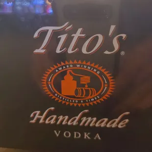 a close up of a sign for tito's handmade vodka