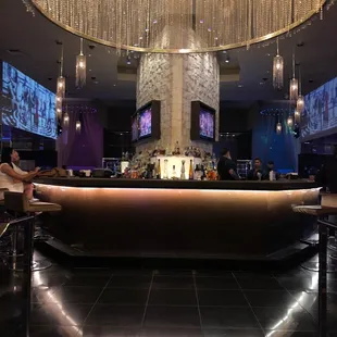 a bar with a large chandelier hanging from the ceiling
