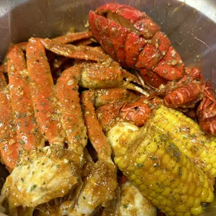 a bowl of crab legs and corn on the cob