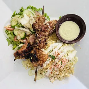 This is the chicken skewers. Tender and juicy roasted chicken over saffron rice with a salad.