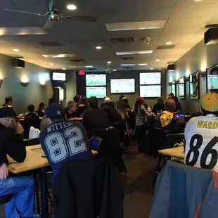 a group of people sitting at tables watching televisions