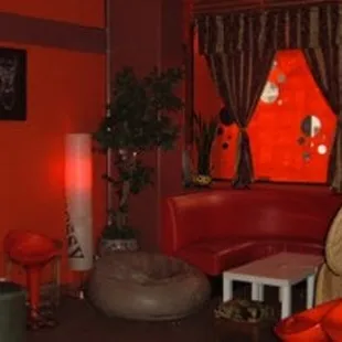 a living room with a red couch and orange chairs