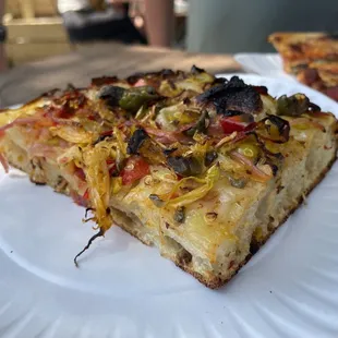a slice of pizza on a paper plate
