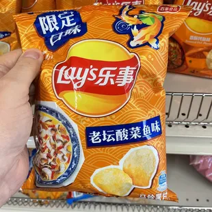 a hand holding a bag of chips