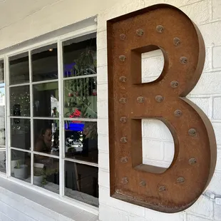 a brick building with a large metal letter b