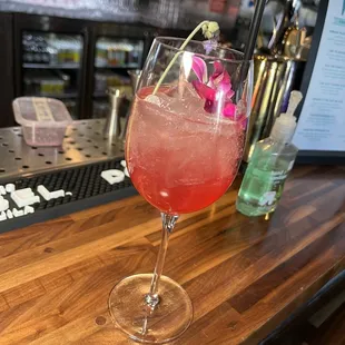 a glass of wine with a flower in it