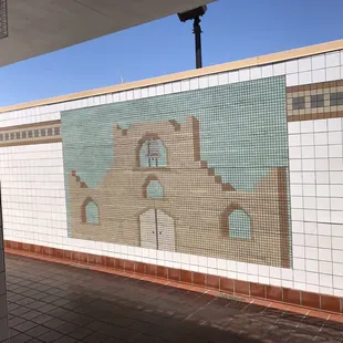 The uncovered half of the men's restroom featured tile art.