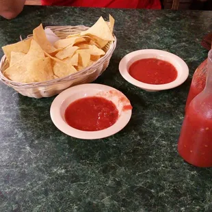 a table with chips and salsa