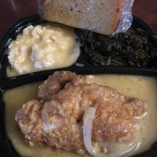 Smothered chicken, mashed potatoes, greens and cornbread.