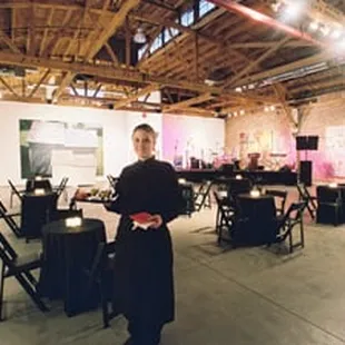 a man standing in a large room with tables and chairs