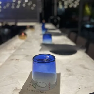 a long table with blue glass jars