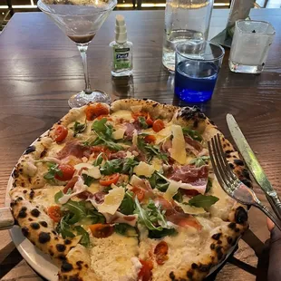 a pizza on a plate with a fork and knife