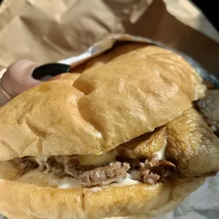 a hand holding a sandwich