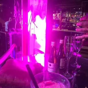 a glass of pink liquid with a spoon in it