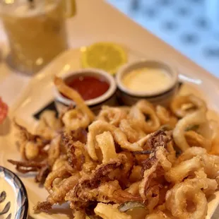 a plate of fried calamails and dipping sauces