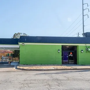 a green building with a black roof