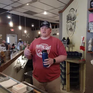 a man in a red shirt holding a cup