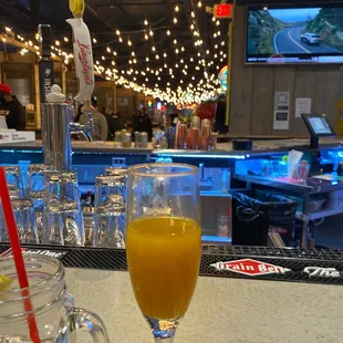 a glass of orange juice on a bar