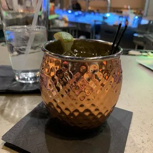a copper mug with a lime garnish in it