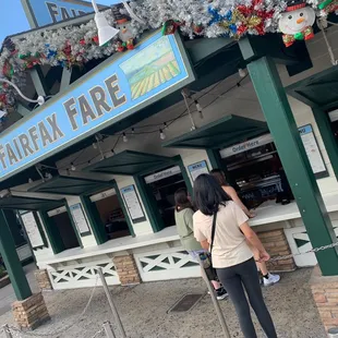 two people standing outside of a restaurant