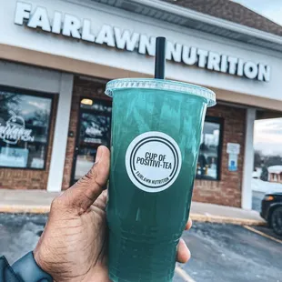 a hand holding a green drink