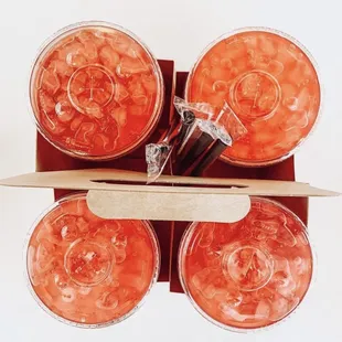 a surfboard and four cups of juice