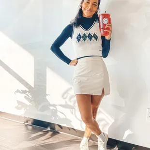 a woman holding a can of soda