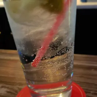 a glass of cold water with a red straw