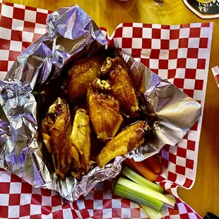 a basket of chicken wings and carrots