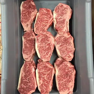 raw steaks in a plastic container