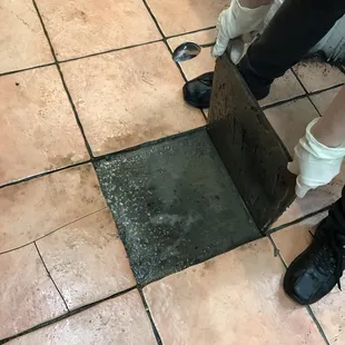 a person removing a piece of tile