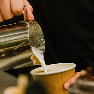 a person pouring a cup of coffee