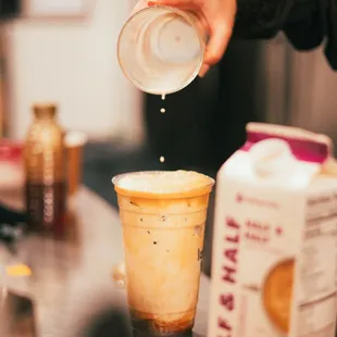a person pouring coffee into a cup