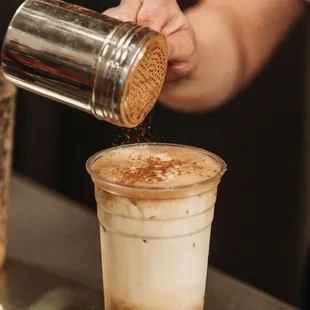 a person pouring coffee into a cup