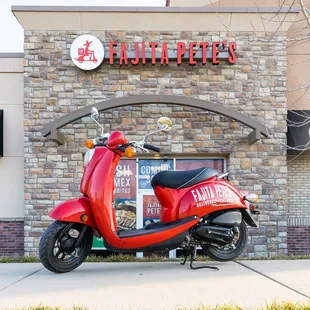 a red scooter parked in front of a restaurant