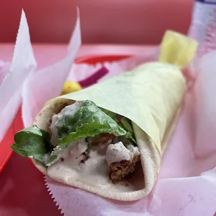a sandwich with lettuce and sauce