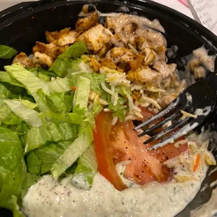 a salad with dressing and a fork