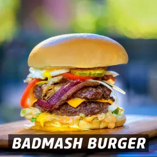 a large hamburger on a wooden board