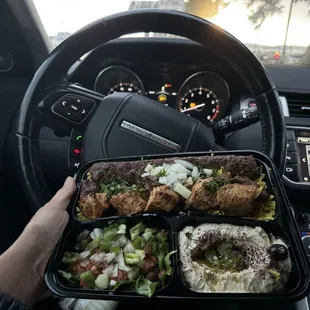 a person holding a tray of food